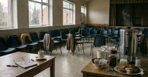 An empty community hall with rows of chairs after a critical incident debrief, representing trauma support and the quiet work of healing.